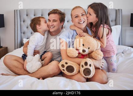 Les enfants aiment partager le moment tendre avec les parents tout en embrassant doucement maman et papa sur la joue. Heureux parents caucasiens passer du temps avec leur Banque D'Images