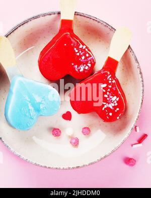 Différents types de crème glacée à la popsicle sur fond rose. Concept d'été atmosphérique. Vue de dessus, plat, espace de copie Banque D'Images