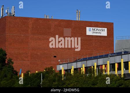 Bâtiment B, un bâtiment en brique rouge avec une signalisation importante, au campus Caulfield de l'Université Monash, avec des arbres au premier plan Banque D'Images