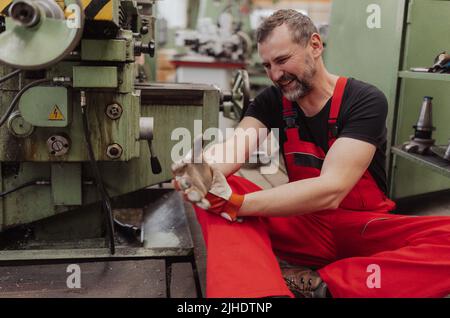 Travailleur souffrant de douleurs après un accident en usine. Soutien de premiers soins sur le concept de lieu de travail. Banque D'Images