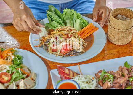 Femme thaïlandaise mangeant somtam pu pla ra avec du riz collant Banque D'Images