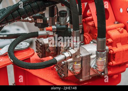 Soupape mécanique du groupe propulseur hydraulique avec tuyaux et connexions sur les machines de l'industrie lourde en gros plan. Banque D'Images