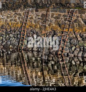 Chains and Ladders et leurs réflexions dans un vieux port de pêche sur la côte de Moray, en Écosse Banque D'Images