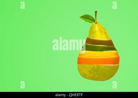 image conceptuelle d'une salade de fruits mélangée dans un mélange en forme de poire de citron vert orange kiwi sur un fond vert coloré Banque D'Images