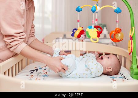 Massage de bébé. Mère faisant de la gymnastique avec l'enfant nouveau-né Banque D'Images