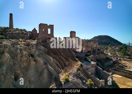 Tir aérien, drone point de vue vieux bâtiments abandonnés de mines de Mazarron à Murcia sur fond bleu ciel pendant la journée ensoleillée d'été. Extraction de minéraux Banque D'Images