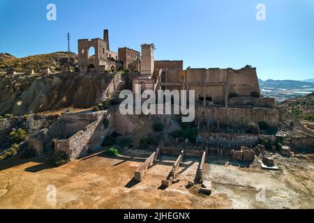 Tir aérien, drone point de vue vieux bâtiments abandonnés de mines de Mazarron à Murcia sur fond bleu ciel pendant la journée ensoleillée d'été. Extraction de minéraux Banque D'Images