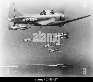 Photo vintage vers 1941 d'un vol des bombardiers de plongée DSD Dauntless d'American Douglas de l'escadron du Scoutisme six (VS-6) en vol au-dessus de l'USS Enterprise. Il a servi avec le corps de la Marine américaine et avec la Marine américaine sur des porte-avions tout au long de la guerre du Pacifique contre l'Empire japonais Banque D'Images