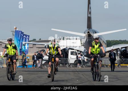 Farnborough, Hampshire, Royaume-Uni. 18 juillet 2022. Le salon des technologies aérospatiales est revenu après la pause en raison de la pandémie de covid avec les plus grandes entreprises mondiales de technologies aéronautiques et spatiales exposant leurs produits dans les airs et au sol. Médecins sur des vélos patrouillant dans les hautes températures Banque D'Images