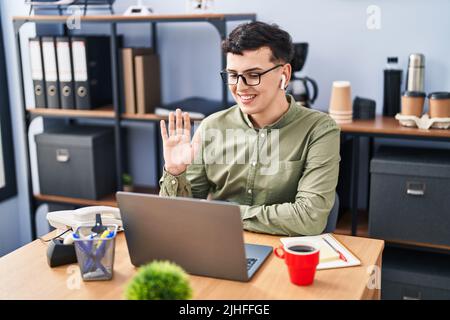 Personne non binaire travaillant au bureau portant des lunettes de vue positive et heureuse debout et souriant avec un sourire confiant montrant des dents Banque D'Images