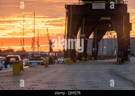 Des grues historiques sur les boulevards au bord de la rivière à Szczecin pendant un lever de soleil spectaculaire Banque D'Images