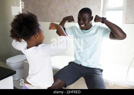 Image d'un père et d'une fille afro-américains heureux qui s'amusent dans la salle de bains Banque D'Images