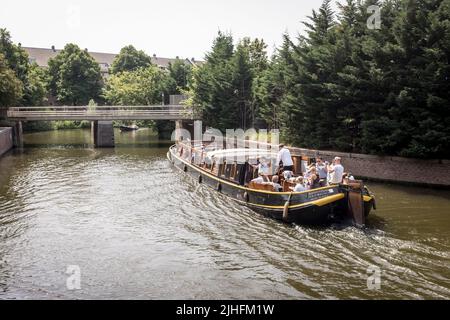 Les gens peuvent profiter d'une croisière sur un bateau sur le canal lors d'une journée chaude et ensoleillée à Amsterdam, pays-Bas. Banque D'Images