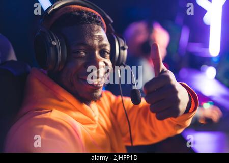 Gros plan d'un homme barbu d'un millénial noir avec un casque professionnel, faisant un selfie pendant un tournoi en ligne avec ses coéquipiers. . Photo de haute qualité Banque D'Images