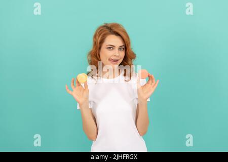 bonne fille tient doux macaron cookie français sur fond bleu Banque D'Images