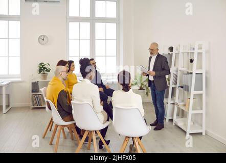 Le directeur commercial senior de l'entreprise donne des instructions aux subordonnés lors de la réunion de travail au bureau. Banque D'Images