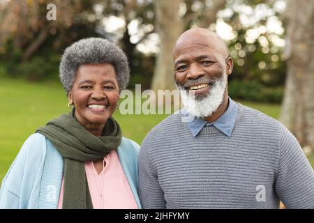 Image d'un heureux couple senior afro-américain posant à la caméra à l'extérieur en automne Banque D'Images