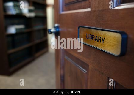 Panneau de bibliothèque sur la porte en bois donnant dans la chambre avec des étagères de livres Banque D'Images