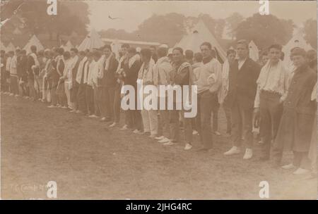 Camp du corps d'instruction des officiers (OTC), Hagley Park, Rugeley, Staffordshire, août 1914. Rangée de jeunes hommes vêts de civils avec des tentes de cloche en arrière-plan. La photographie a été prise au cours du premier mois de la première Guerre mondiale et montre les premiers bénévoles de l'Armée de Kitchener Banque D'Images