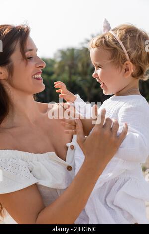 Vue latérale de la mère regardant la petite fille en robe à Valence Banque D'Images