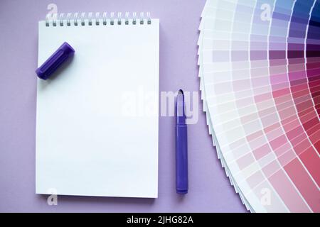 Échantillons de peinture, nuance multi-couleurs pour la conception. Arrière-plan lilas, bloc-notes, marqueur violet. Copier l'espace. Banque D'Images