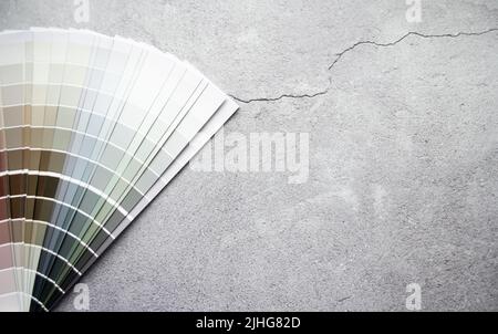 Échantillons de peinture nuance de couleurs pour le design intérieur. Fond gris en béton fissuré, couleurs terre. Banque D'Images