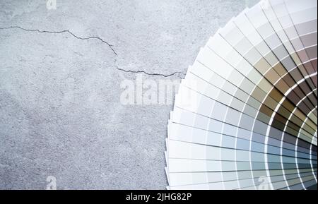 Échantillons de peinture nuance de couleurs pour le design intérieur. Fond gris en béton fissuré, couleurs terre. Banque D'Images