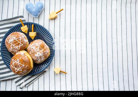 Bonne Hanoukkah.Un régal traditionnel de beignets avec David star et dreidel fait à partir de fromage et de bâtonnets de biscuit.Copier l'espace. Banque D'Images