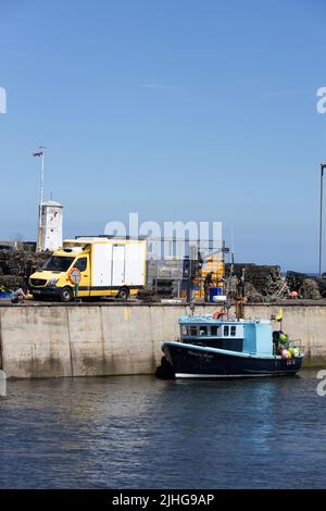 Bateau de pêche déchargeant ses prises au port de Seahouses, Northumberland, Angleterre. Banque D'Images