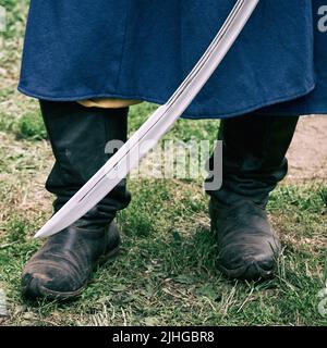 Un homme dans un uniforme militaire suédois vintage avec un sabre dans ses mains. Reconstruction des événements de la guerre russo-suédoise Banque D'Images