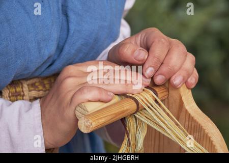 Une ancienne femme romaine fabrique des fils et des ragoûts à partir de laine d'époque. Reconstruction des événements de l'Empire romain Banque D'Images