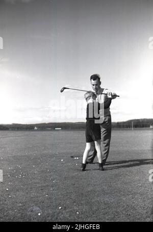 1950s, historique, John Reekie professionnel de golf du Golf House Club, Elie, Fife, Écosse, Royaume-Uni et fils de Tom Reekie, célèbre club-maker, donnant une leçon de golf à un jeune garçon. Banque D'Images