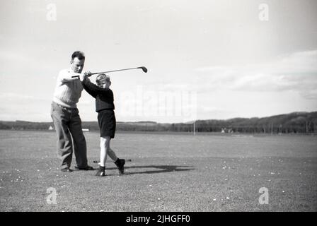 1950s, historique, John Reekie professionnel de golf du Golf House Club, Elie, Fife, Écosse, Royaume-Uni et fils de Tom Reekie, célèbre vilier club-maker, donnant une leçon de golf à un jeune garçon. Banque D'Images