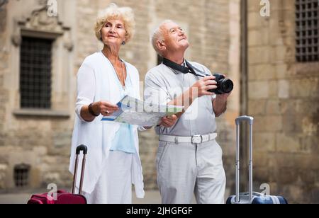 Femme et homme senior voyageant ensemble à la recherche d'une destination avec plan de la ville Banque D'Images