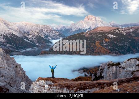 Un touriste se dresse au-dessus du brouillard au bord d'une falaise dans les Dolomites.Emplacement Auronzo rifugio dans le parc national de Tre Cime di Lavaredo, Dolomites, Trentin-Haut-Adige, Italie Banque D'Images