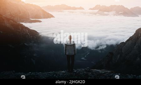 Un touriste se dresse au-dessus du brouillard au bord d'une falaise dans les Dolomites.Emplacement Auronzo rifugio dans le parc national de Tre Cime di Lavaredo, Dolomites, Trentin-Haut-Adige, Italie Banque D'Images