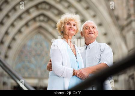 Couple senior debout près des rambardes en fer devant la cathédrale Banque D'Images