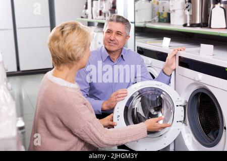 Les couples choisissent la machine à laver à la maison dans la boutique Banque D'Images