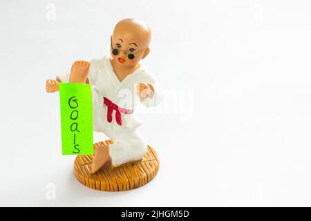 Carte accrochée sur le pied karaté sportif 'Goals'. Arrière-plan blanc Banque D'Images