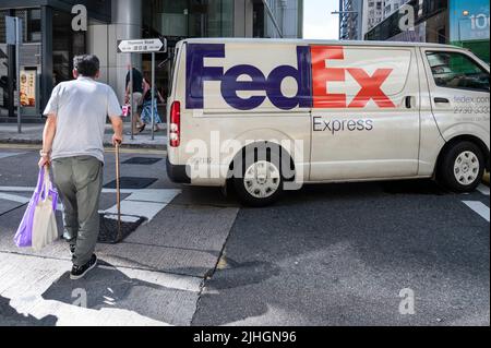 Un piéton passe devant un minibus de livraison American FedEx Express à Hong Kong. Banque D'Images