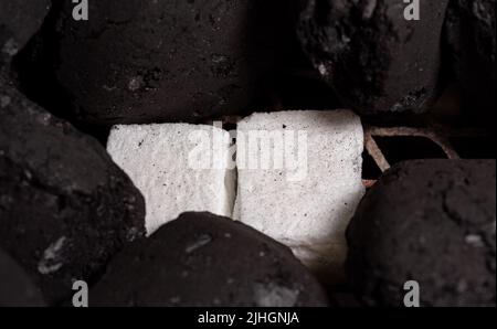 Allumer un feu de barbecue. Briquette et briquette blanche. Flamme au charbon de bois. Banque D'Images