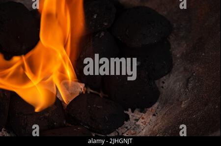 Allumer un feu de barbecue. Briquette et briquette blanche. Flamme au charbon de bois. Banque D'Images