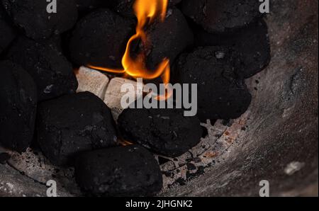 Allumer un feu de barbecue. Briquette et briquette blanche. Flamme au charbon de bois. Banque D'Images