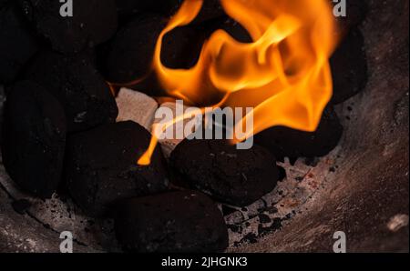 Allumer un feu de barbecue. Briquette et briquette blanche. Flamme au charbon de bois. Banque D'Images