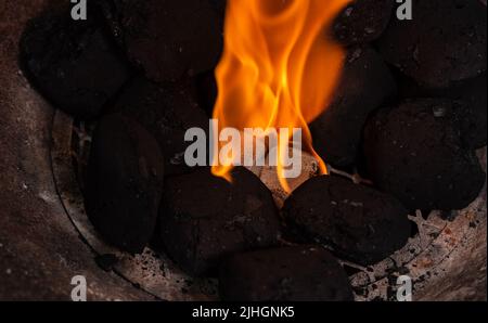 Allumer un feu de barbecue. Briquette et briquette blanche. Flamme au charbon de bois. Banque D'Images