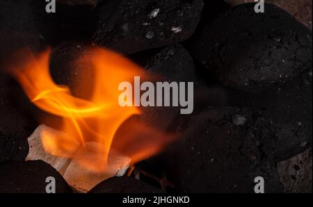 Allumer un feu de barbecue. Briquette et briquette blanche. Flamme au charbon de bois. Banque D'Images