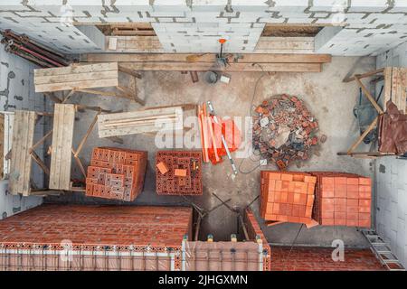 Chambre dans une maison de campagne en construction avec matériaux de construction et outils. Directement au-dessus de la vue aérienne Banque D'Images