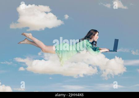 Vol stationnaire dans l'air. Surprise fille excitée robe à volant lévitant avec ordinateur portable, dactylographiant clavier, lisant des nouvelles choquantes sur ordinateur. Voler dans le ciel. Composition de collage le jour ciel bleu ciel nuageux Banque D'Images