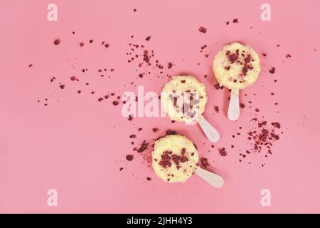 Crème glacée au chocolat blanc, au coconot et aux morceaux de framboises séchés sur fond rose Banque D'Images