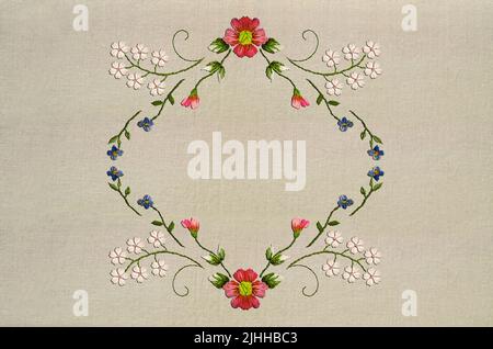 Broderie cadre en forme de diamant de fleurs sauvages avec des fleurs bleues, des fleurs blanches sur des branches incurvées et une fleur rose avec des bourgeons et des feuilles sur un beige Banque D'Images